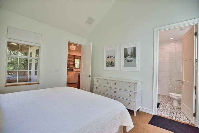 bedroom with carpet flooring, ensuite bath, and lofted ceiling