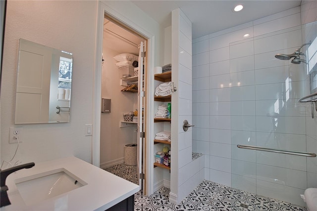 bathroom featuring tiled shower, vanity, and tile patterned floors