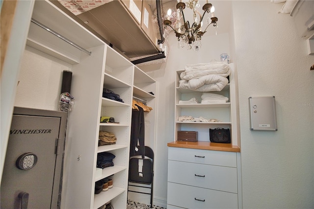 walk in closet featuring a notable chandelier