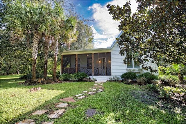 view of front facade featuring a sunroom and a front yard