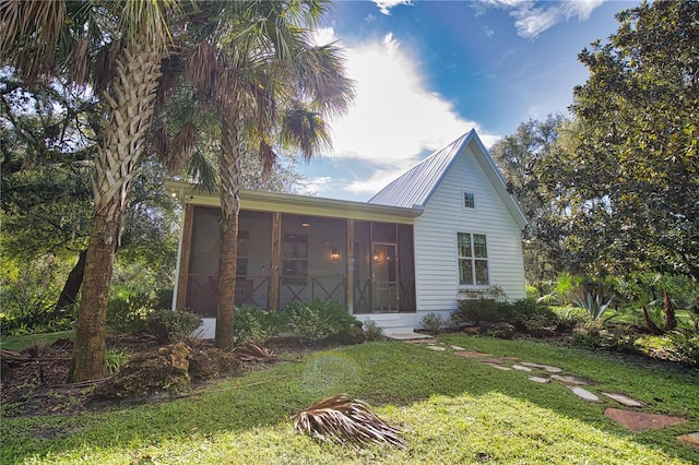 view of front facade with a sunroom and a front lawn