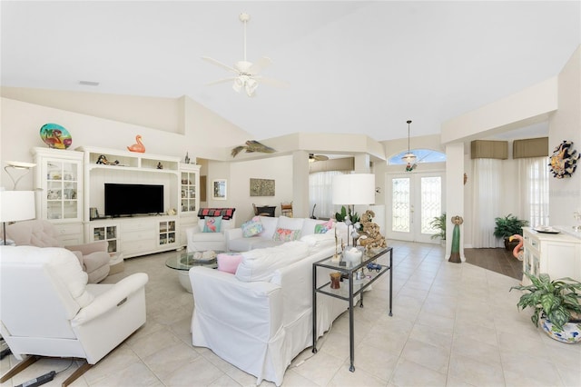 tiled living room featuring ceiling fan, vaulted ceiling, and french doors