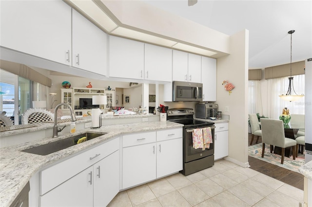 24337 Contra Costa Ln, Punta Gorda, FL 33955 - kitchen with stainless steel appliances, white cabinets, light stone countertops, hanging light fixtures, and light tile patterned floors