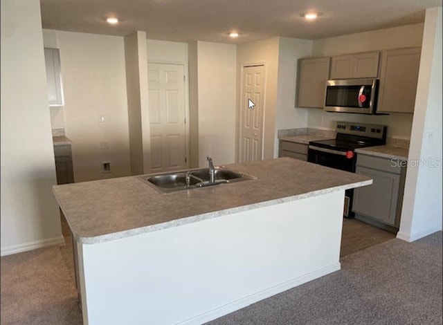 kitchen with sink, stainless steel appliances, gray cabinetry, and an island with sink