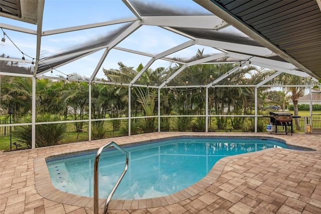 view of swimming pool with a grill, a lanai, and a patio area