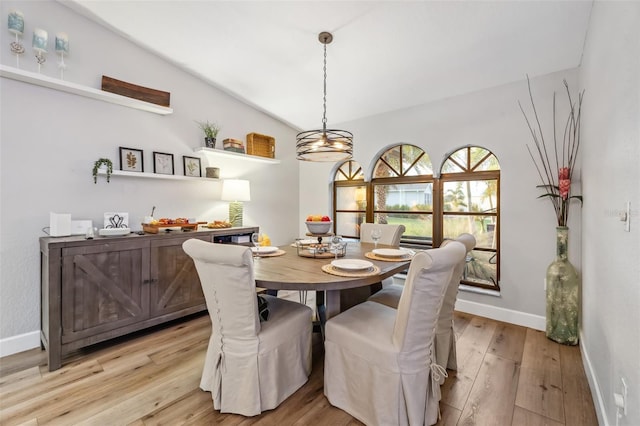 dining room with vaulted ceiling and light wood-type flooring