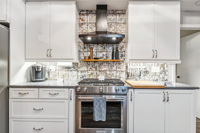 kitchen featuring stainless steel appliances, wall chimney range hood, and white cabinets