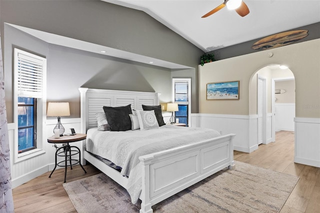 bedroom with multiple windows, vaulted ceiling, ceiling fan, and light hardwood / wood-style flooring