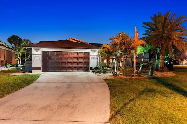 ranch-style house featuring a garage and a front yard