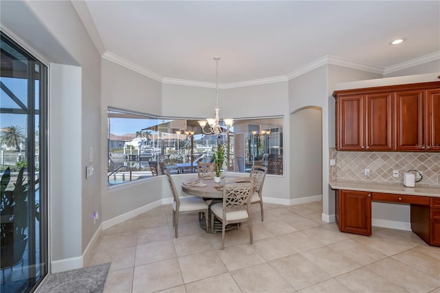 dining area with an inviting chandelier, crown molding, and light tile patterned floors