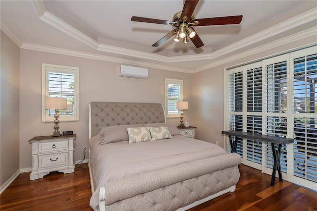 bedroom with ornamental molding, ceiling fan, dark hardwood / wood-style flooring, a tray ceiling, and a wall mounted air conditioner