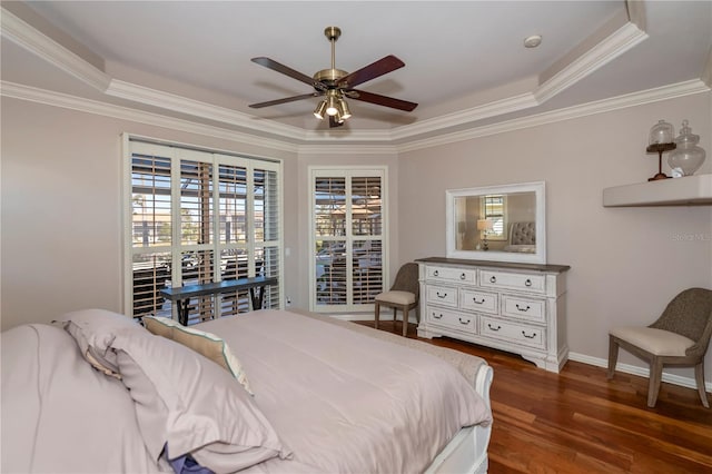 bedroom with ceiling fan, dark wood-type flooring, a raised ceiling, and crown molding