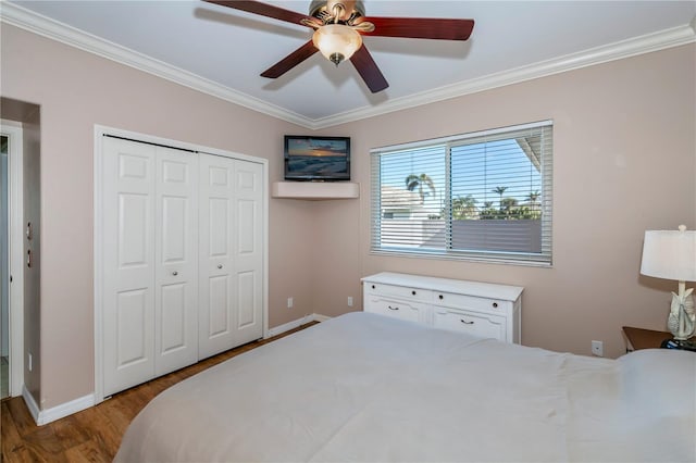 bedroom featuring ceiling fan, light wood-type flooring, ornamental molding, and a closet