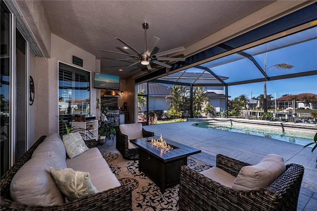 view of patio / terrace with a lanai and an outdoor living space with a fire pit