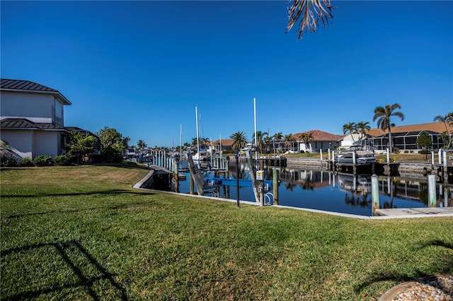 view of dock with a yard and a water view