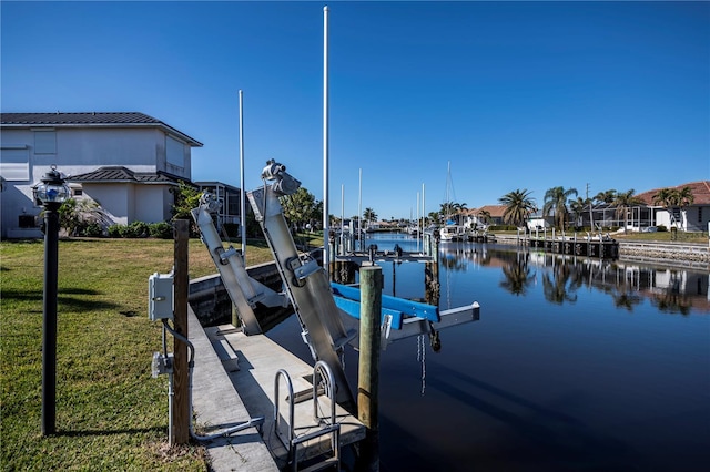 view of dock with a yard and a water view