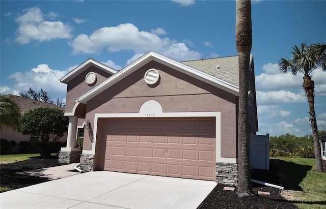 view of front facade with concrete driveway, an attached garage, stone siding, and stucco siding