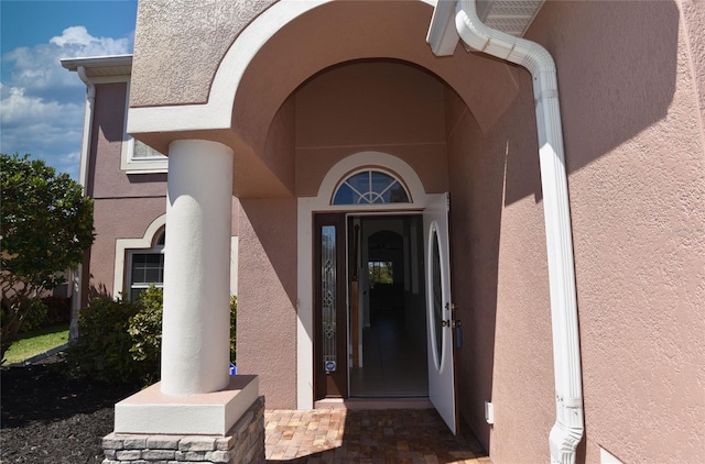 entrance to property featuring stucco siding