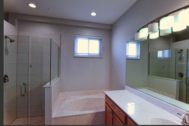 bathroom featuring vanity, a bath, recessed lighting, and a stall shower