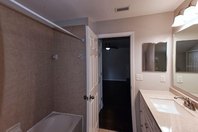 bathroom featuring visible vents, a textured ceiling, washtub / shower combination, and vanity