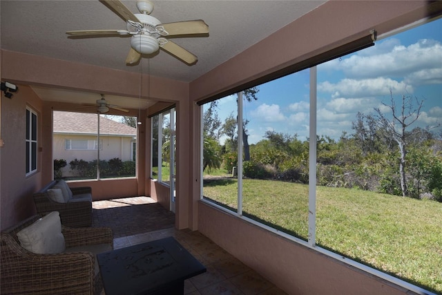 sunroom / solarium featuring a healthy amount of sunlight and ceiling fan