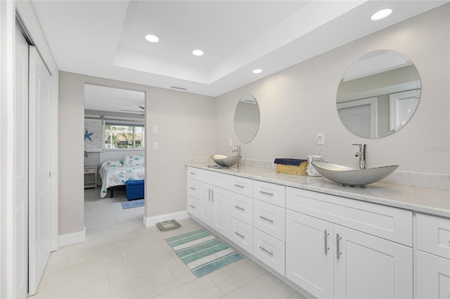 bathroom with vanity and a tray ceiling