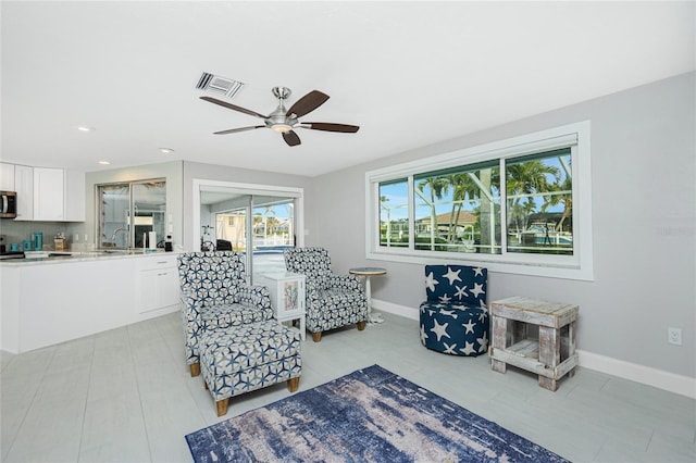 living area featuring sink and ceiling fan