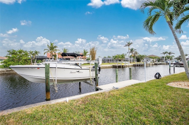 view of dock with a water view and a lawn