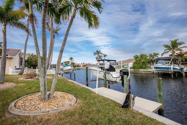 view of dock with a water view and a lawn