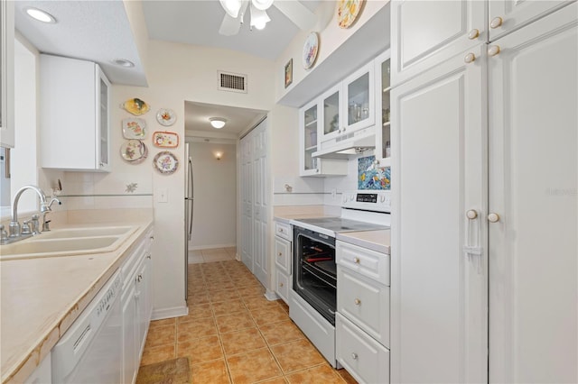 kitchen featuring white cabinetry, sink, light tile patterned floors, and white appliances