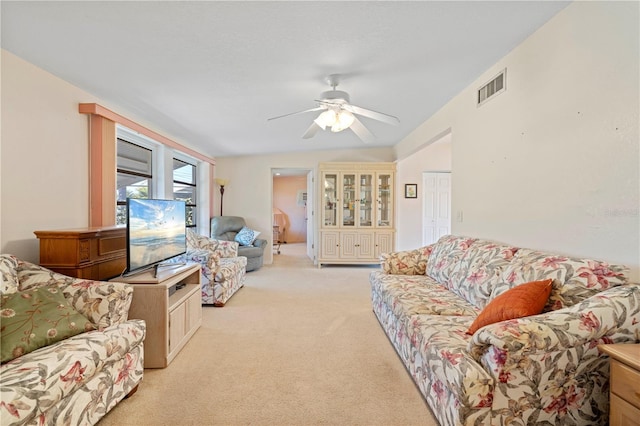 carpeted living room with ceiling fan