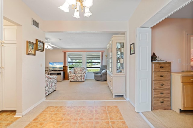 hall featuring a notable chandelier and light colored carpet