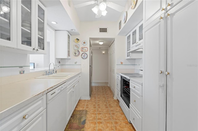 kitchen featuring white appliances, ceiling fan, sink, light tile patterned floors, and white cabinetry