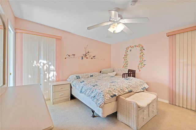 bedroom with ceiling fan, light carpet, and multiple windows