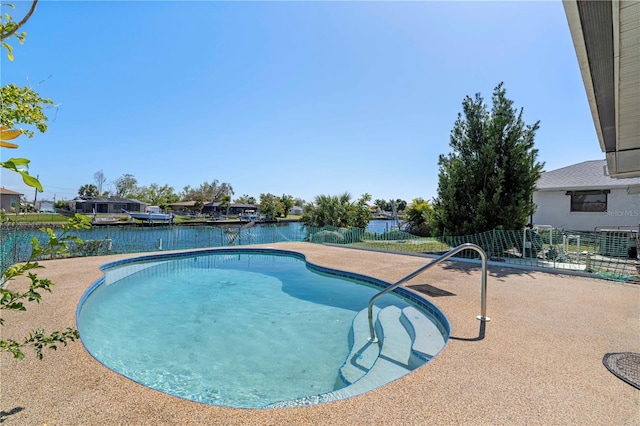 view of swimming pool featuring a patio and a water view