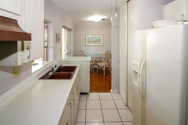 kitchen with white refrigerator with ice dispenser, light tile patterned floors, and sink