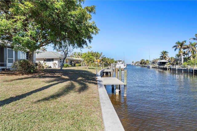 view of dock featuring a lawn and a water view