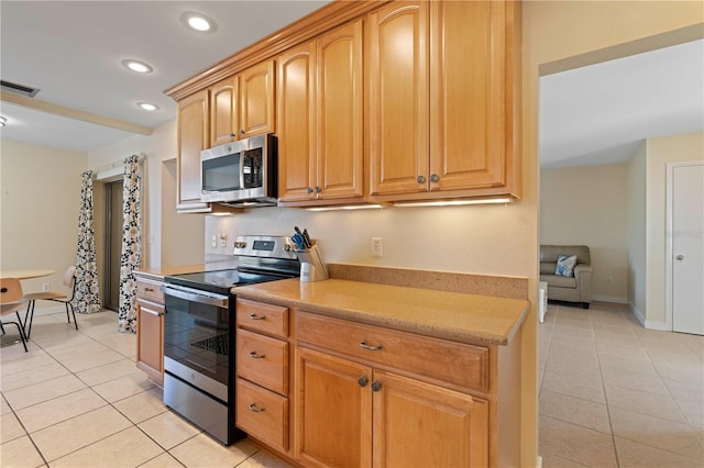 kitchen with light tile patterned flooring and appliances with stainless steel finishes