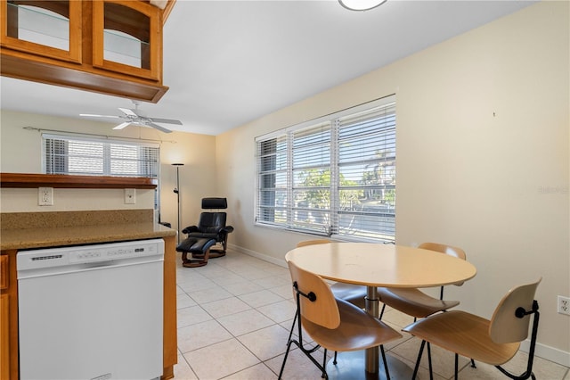 tiled dining space with ceiling fan and a healthy amount of sunlight