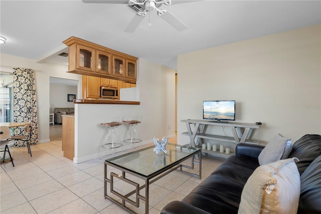 living room featuring ceiling fan and light tile patterned floors