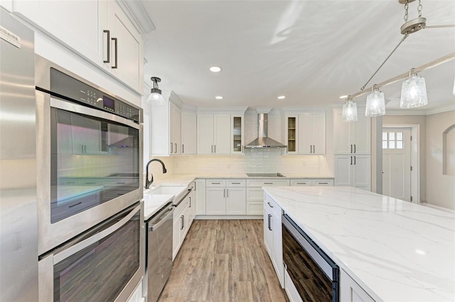 kitchen with backsplash, white cabinetry, pendant lighting, and wall chimney exhaust hood