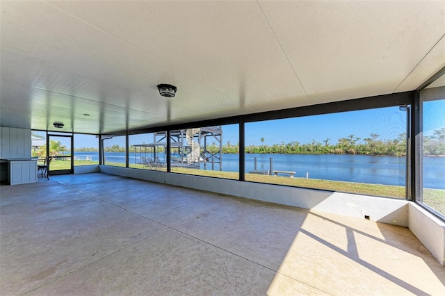 unfurnished sunroom with a water view