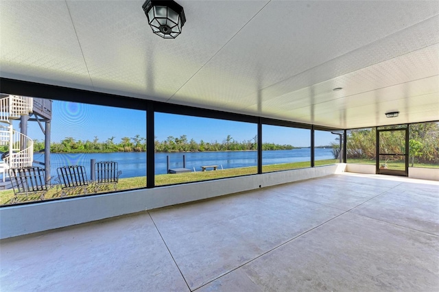 unfurnished sunroom with a healthy amount of sunlight and a water view