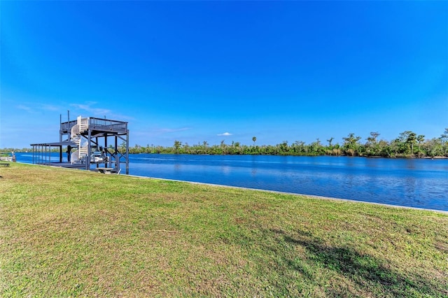 view of dock with a yard and a water view