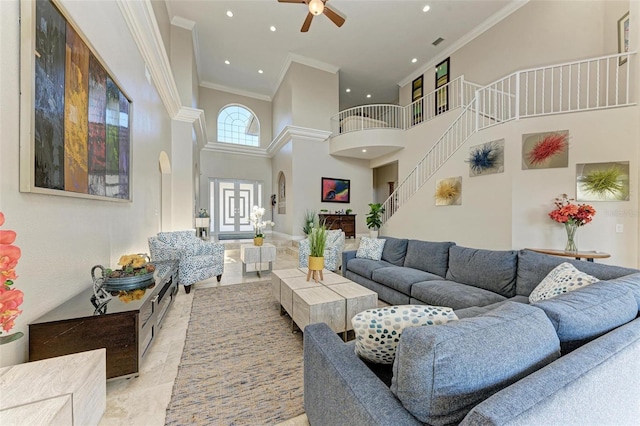 living room featuring ceiling fan, crown molding, and a towering ceiling