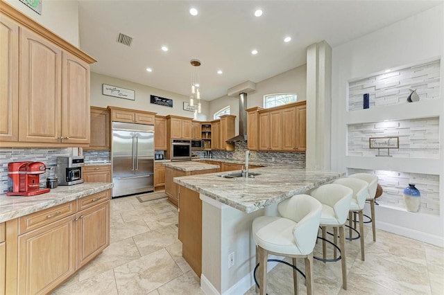 kitchen with sink, stainless steel appliances, a kitchen breakfast bar, kitchen peninsula, and decorative light fixtures