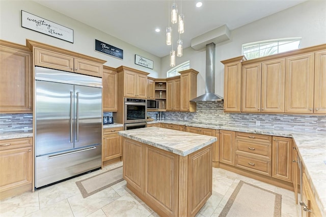 kitchen featuring wall chimney exhaust hood, light stone countertops, tasteful backsplash, a kitchen island, and stainless steel appliances