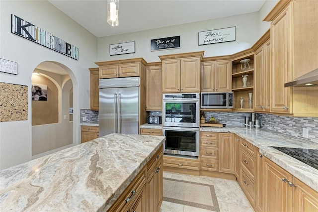 kitchen with tasteful backsplash, light stone countertops, light tile patterned floors, and appliances with stainless steel finishes