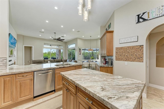 kitchen featuring decorative light fixtures, stainless steel dishwasher, ceiling fan, and sink