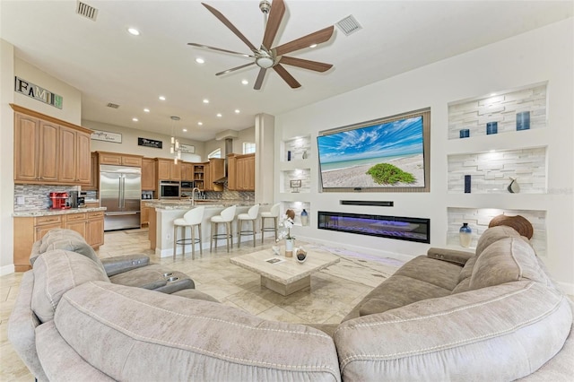 living room with ceiling fan and sink